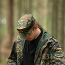 Man wearing genuine German army Flecktarn cap and jacket in BW woodland camo pattern in forest setting