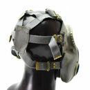 Side view of a vintage Polish military MP-4 gas mask in olive grey with adjustable straps and a rubber facepiece