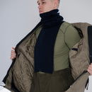 Man wearing a blue Genuine Dutch Army scarf neck tube with a green shirt and open winter jacket showing quilted lining