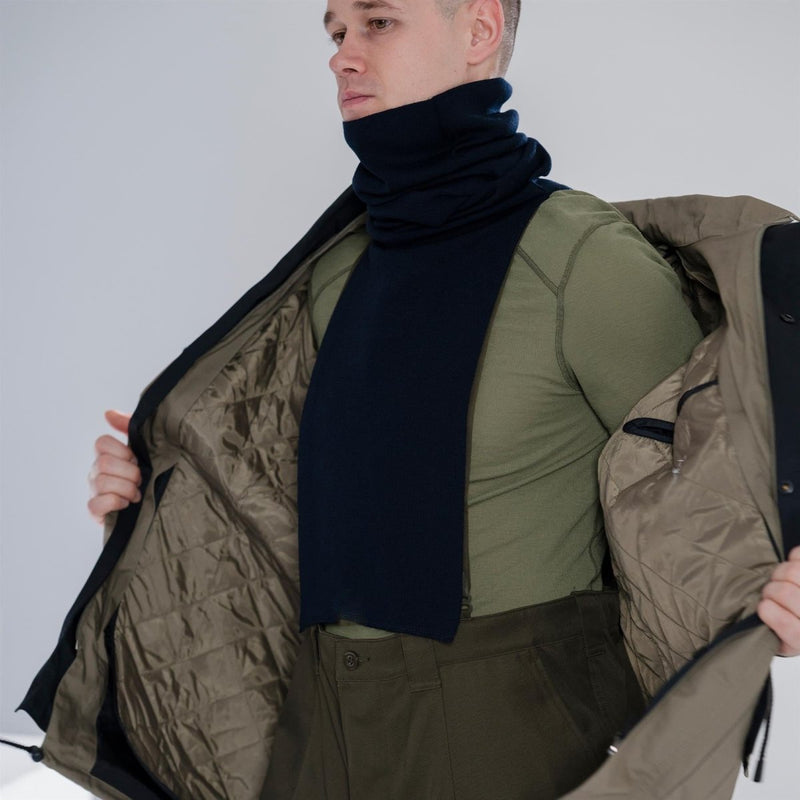 Man wearing a blue Genuine Dutch Army scarf neck tube with a green shirt and open winter jacket showing quilted lining