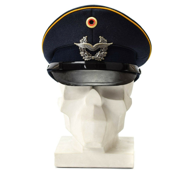 Casquette à visière à visière bleue vintage des forces aériennes allemandes de la Luftwaffe avec insigne militaire et passepoil jaune affiché sur un buste blanc