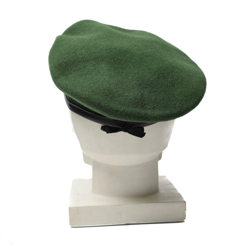 Green wool German police beret hat with metal cockade insignia displayed on a white mannequin head.