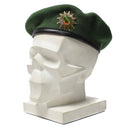 Genuine German police green wool beret with metal cockade insignia displayed on white mannequin head