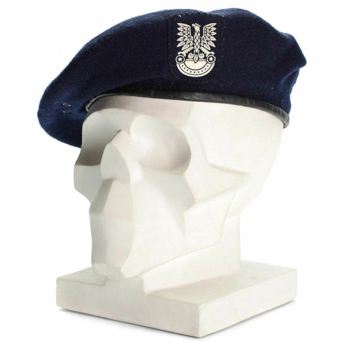 Echte Poolse militaire blauwe baret met embleem op het hoofd van de witte mannequin, symbool voor eer en service