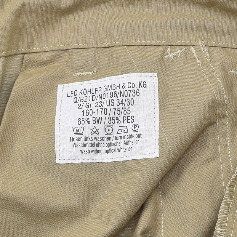 Close-up of care label on Leo Kohler Commando tactical field pants in Tropentarn camo showing fabric details and washing instructions.