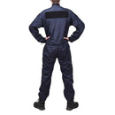 Back view of original French police blue anti-static coverall jumpsuit worn by officer standing with hands on hips.