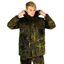 Man wearing original German army GoreTex flecktarn waterproof camouflage rain jacket with hood up