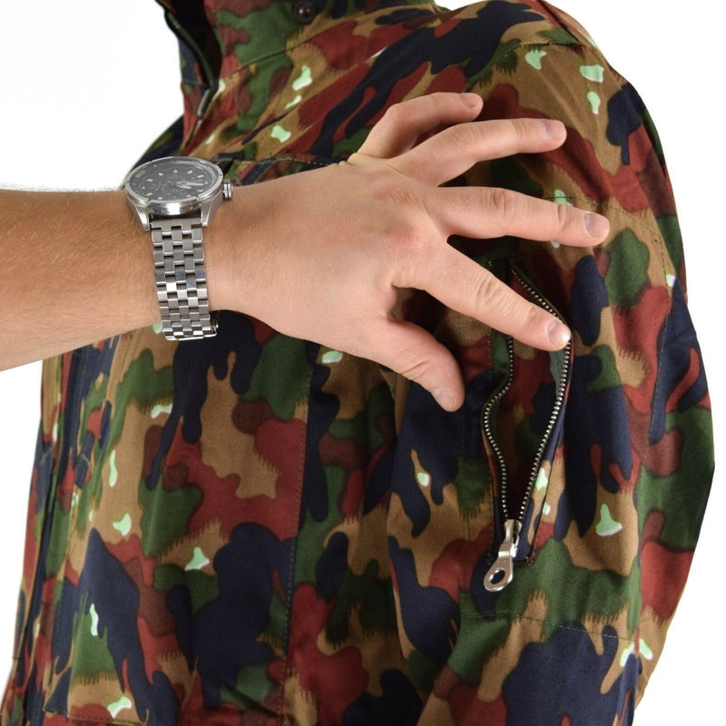 Close-up of hand opening zippered pocket on original Swiss army Alpenflage camouflage coverall suit sleeve
