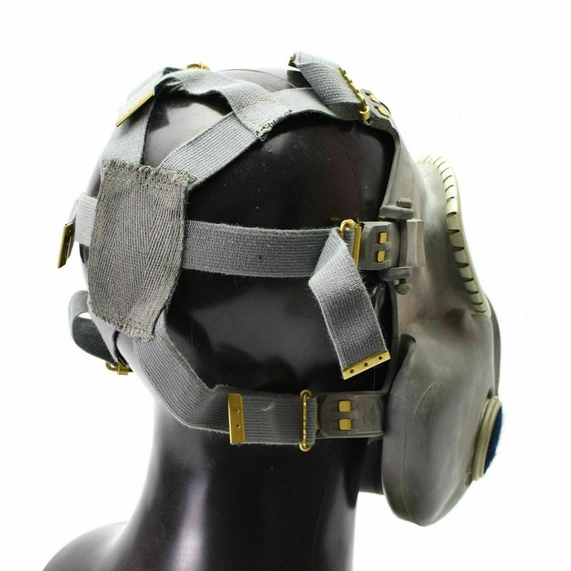Side view of a vintage Polish military MP-4 gas mask in olive grey with adjustable straps and a rubber facepiece