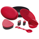 Complete red and black Primus Frigg W Piezo camping mess kit with plates, utensils, and cookware for outdoor meals.