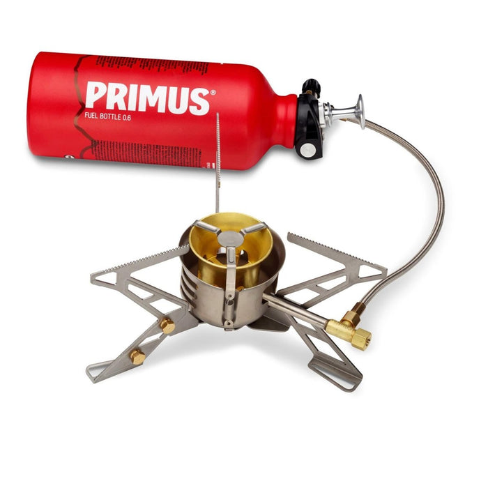 Primus MultiFuel III wandelkachel met rode brandstoffles, compact draagbaar ontwerp voor buitenkamperen en multi-fuel gebruik