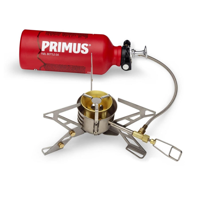 Primus OmniFuel II multi-fuel kampeerkooktoestel met rode brandstoffles en opvouwbare statiefbrander voor buiten koken.