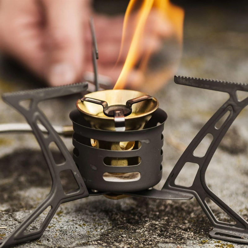 Primus OmniLite Ti titanium camping stove burner with flame, designed for lightweight, multi-fuel outdoor cooking.