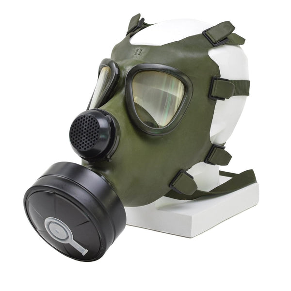 Vintage Romanian M74 full face olive green gas mask with black filter and adjustable straps on white display mannequin